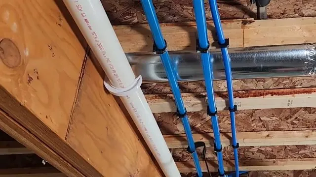 Blue PEX supply lines running through an open joist bay beside a white drain pipe