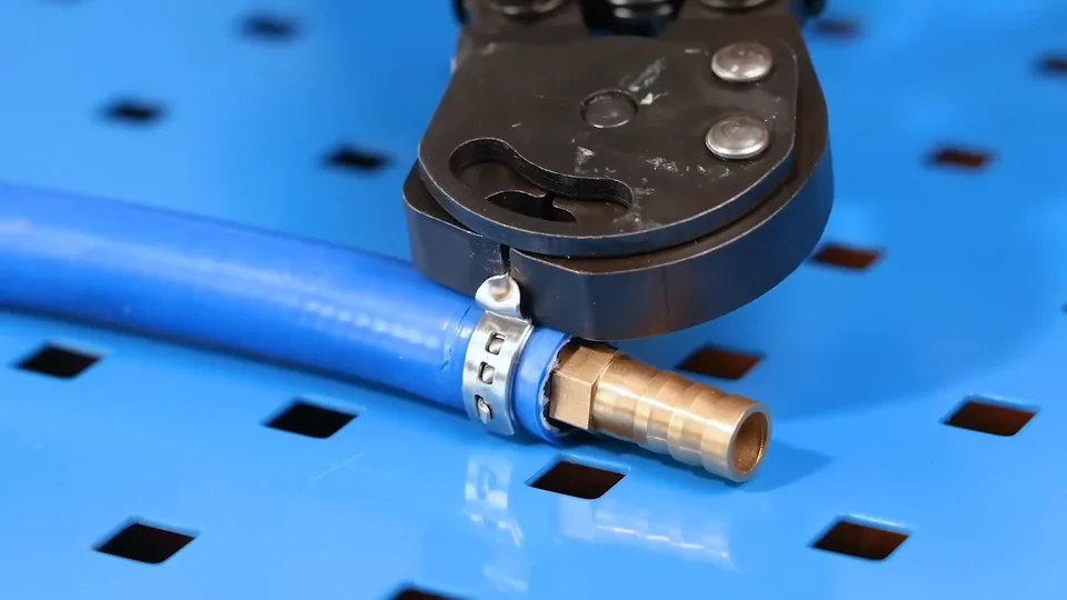 Crimp tool closing a brass fitting on a blue PEX line