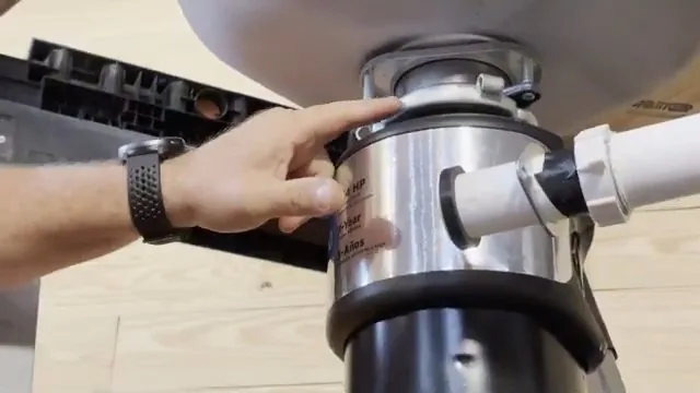 Hand seating a food waste disposer onto the drain connection under a sink