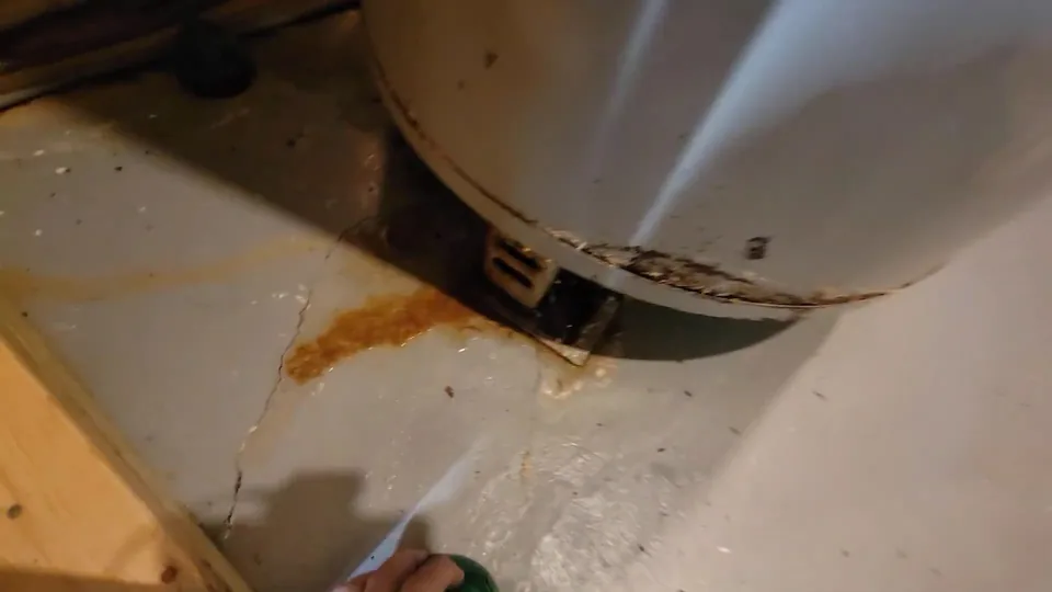 Rust staining on the floor at the base of a water heater tank