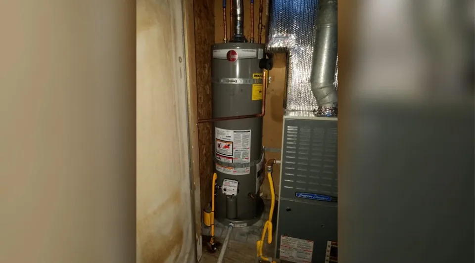 Tank water heater installed in a narrow wall alcove
