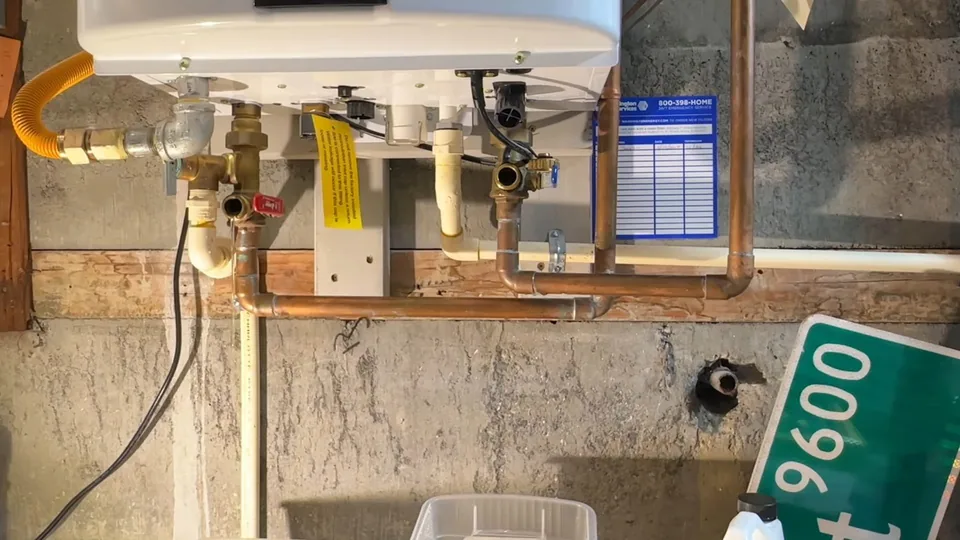 Tankless water heater in a basement with copper water lines and a yellow gas connector