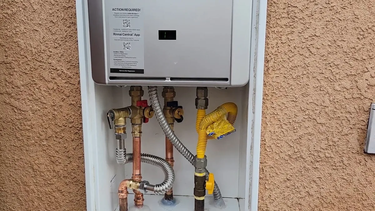 Wall-mounted tankless water heater with water and gas connections below it